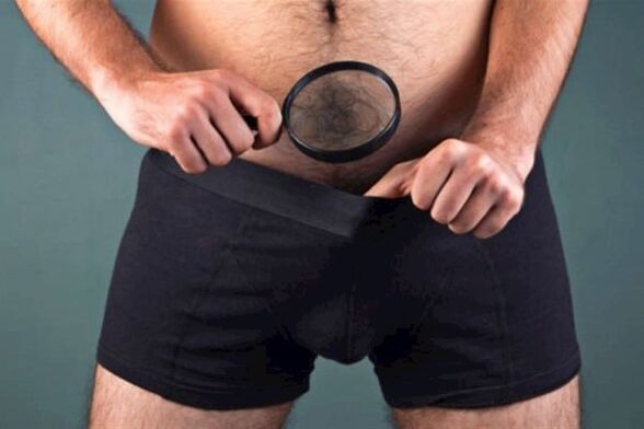un homme avec une loupe examine son pénis et veut l'épaissir